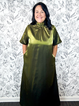Mistletoe Martini Midi Dress, ENTRO. Olive green metallic mock neck with bow at back, short sleeves, side seam pockets, midi length or maxi if you are 5"3 or below.